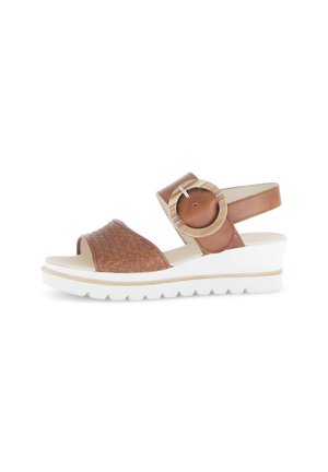 Brown woven leather sandals with ankle strap, circular accent, and a white wedge sole. Features a textured upper and smooth lining.
