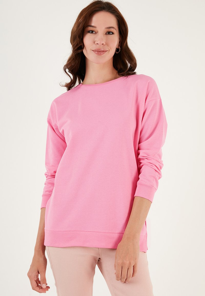 Felpa rosa a girocollo con maniche lunghe. Tessuto morbido, vestibilità comoda, polsini e orlo a costine. Design semplice senza motivi o accenti visibili.