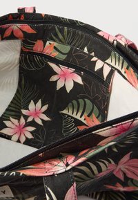Sac en tissu noir avec des fleurs tropicales roses et blanches ainsi que des feuilles vertes, équipé d'une poche intérieure zippée et d'une fermeture principale zippée.