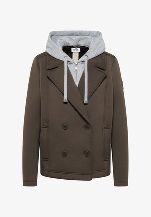 Ciemnooliwkowa, dwurzędowa marynarka z dużymi klapami nałożona na jasnoszarą bluzę z kapturem zapinaną na zamek, ze sznurkami.