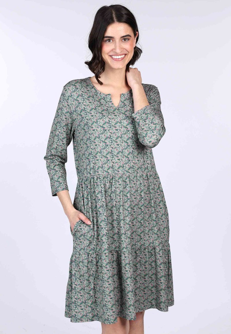 Blumenmuster-Kleid in Grün mit V-Ausschnitt, Dreiviertelärmeln und Taschen. Gestuftes Design mit lässiger Passform und weicher Stoffstruktur.