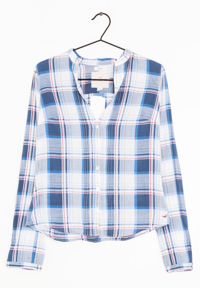 Chemise à manches longues à carreaux bleus et blancs avec des accents rouges, présentant un col en V, des boutons sur le devant et un ourlet décontracté. Tissu léger.