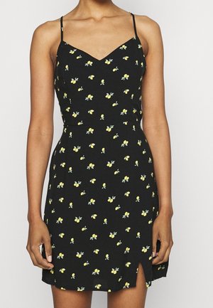 Schwarzes Kleid mit gelbem Zitronenblütenmuster, dünnen verstellbaren Trägern, V-Ausschnitt, figurbetonter Taille und seitlichem Schlitz am Saum.