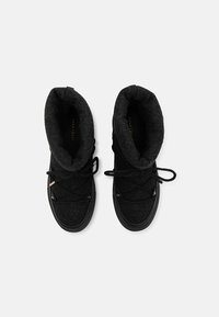 Botas negras hasta el tobillo con una parte superior de tejido suave y texturizado, cordones en la parte frontal y suelas de goma. Presenta un puño acolchado y sutiles detalles metálicos.