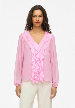 Blusa rosa con escote en V, mangas largas y un diseño frontal con volantes. Fabricada con un tejido ligero y de textura suave.