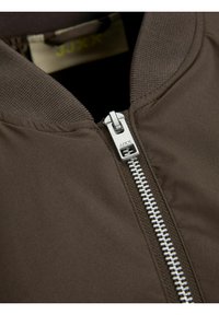 Bruine bomberjack met een gladde stof, ribgebreide kraag en een zilveren rits met branding. Opvallende stikseldetails langs de ritslijn.