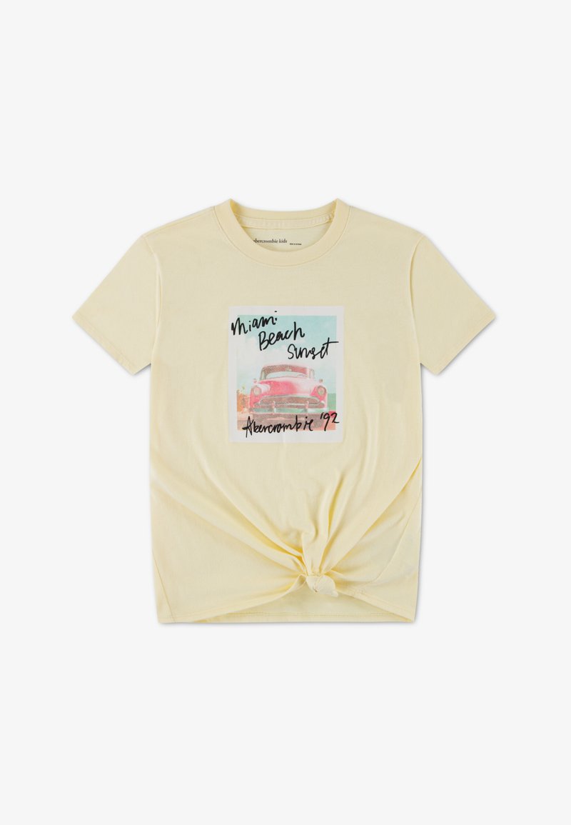 Κίτρινο βαμβακερό t-shirt με δέσιμο στο μπροστινό μέρος, με γραφικό σχέδιο ενός vintage αυτοκινήτου και κείμενο που γράφει «Miami Beach Sunset».