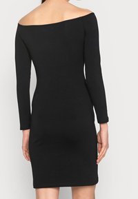Czarna sukienka bez ramiączek, z długimi rękawami, dopasowana, wykonana z miękkiego materiału. Bezszwowy dekolt i ham z minimalnymi detalami.