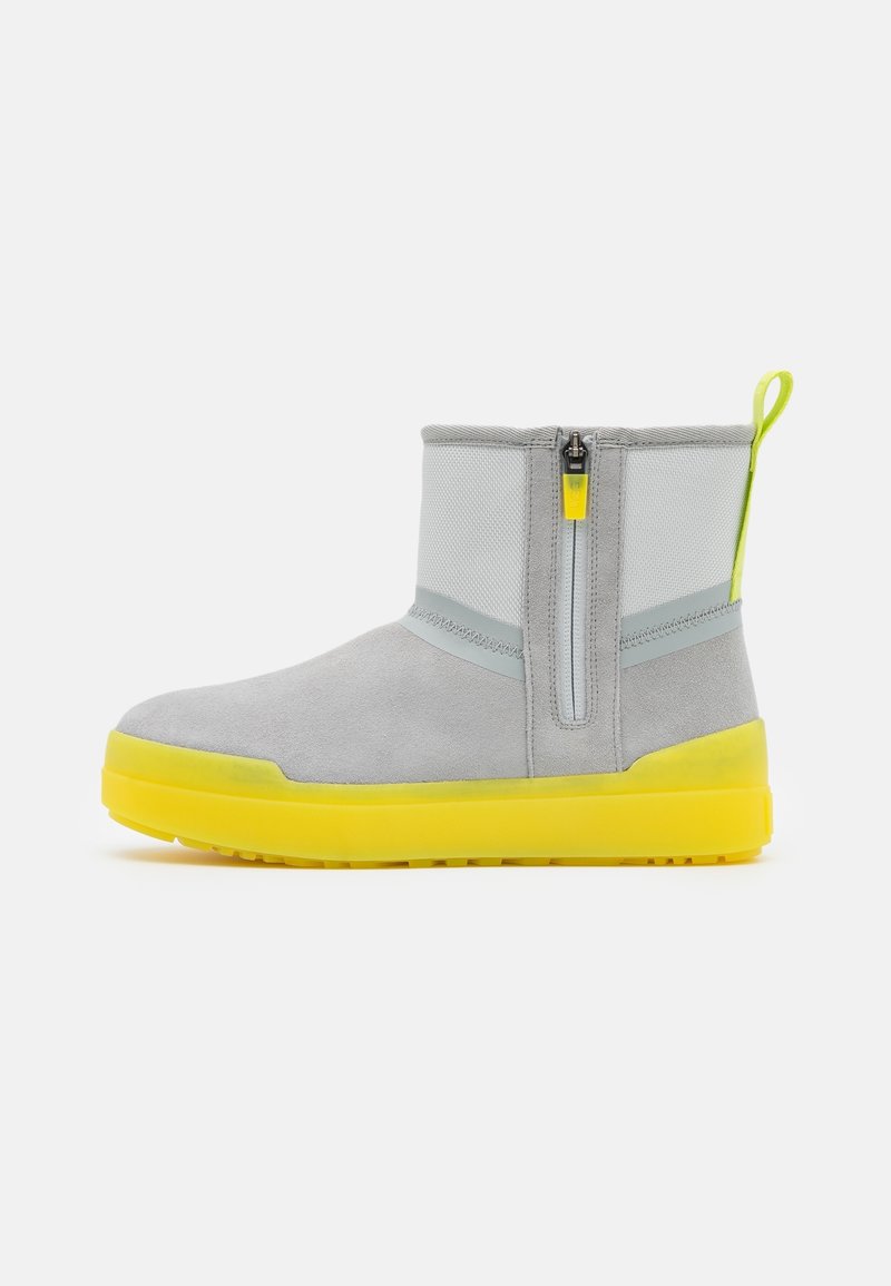 Mid-height gray suede and fabric boot with yellow pull tab, zipper on side, and thick yellow rubber sole, shown against white background.