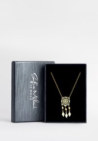 Guldhalsband med cirkulär hänge som har en intrikat urklippt design och tre hängande accent i diamantform. Presenterat i en svart låda.