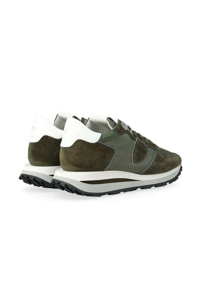 Un paio di sneakers verde oliva e bianche con dettagli in suede e pelle, suole in gomma nera e stringhe, viste dal retro e di lato.
