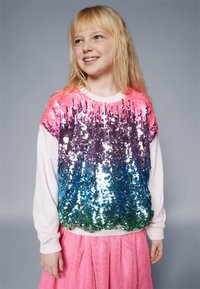 Svetra sa šljokicama koji prikazuje gradijent ružičastih, ljubičastih, plavih i zelenih šljokica. Bele rukave i rebrasti izrez. Uparen s ružičastom suknjom.