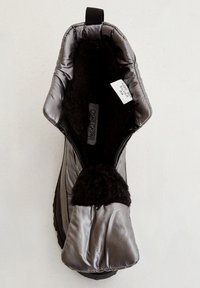 Botte de cheville noire rembourrée avec un extérieur brillant, doublure noire douce, fermeture éclair et une languette en boucle en haut pour un enfilage facile.
