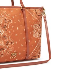 Narandžasta torba s uzorkom, ukrašena paisley dizajnom, izrađena od čvrste tkanine, s smešnim kožnim aksesorima, zlatnim hardverom i podešivim remenom za rame.