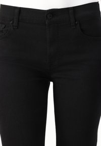 Mustad denim teksad, millel on sobiv disain, nuppude kinnis, eesmine taskud ja nähtavad õmbluste detailid. Sile tekstuur.