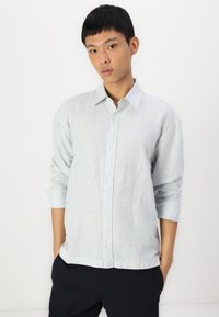 Camisa de botão riscada em azul claro e branco, com colarinho espalhado, mangas longas e um ajuste descontraído com barra reta.