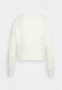 Suéter blanco de punto con un patrón de diamantes, de longitud corta, con puños y dobladillo de canalé, y una superficie texturizada. Ideal para superponer.
