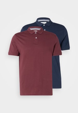 Two short-sleeve polo shirts, one burgundy and one navy. Both have a collared neck and two-button placket with subtle striped accents.