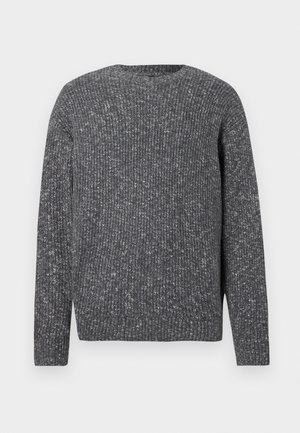 Pikkade varrukatega tumehall soonikkoes kampsun, millel on ümar kaelus ja täpiline tekstuur.