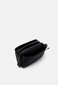 Schwarzes Reißverschluss-Portemonnaie mit strukturierter Oberfläche, ausgestattet mit zwei Fächern und einem roten Akzent am Reißverschluss. Kompaktes Design.