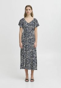 Marineblaues Maxikleid mit einem weißen Blumenmuster, kurzen, flatternden Ärmeln, V-Ausschnitt und einer taillierten Taille für eine entspannte Passform.