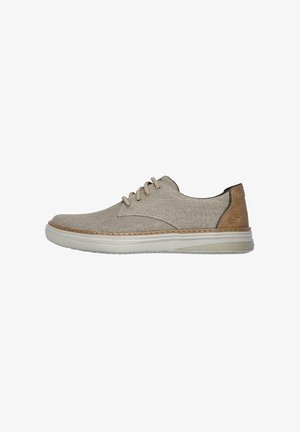 Scarpa in tela beige con parte superiore testurizzata, accento in pelle marrone sul tallone, suola chiara e lacci beige. Design classico con lacci.