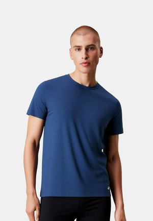 Temno modra majica s kratkimi rokavi iz gladkega, lahkega materiala z okroglim izrezom in majhnim logotipom na spodnjem robu.