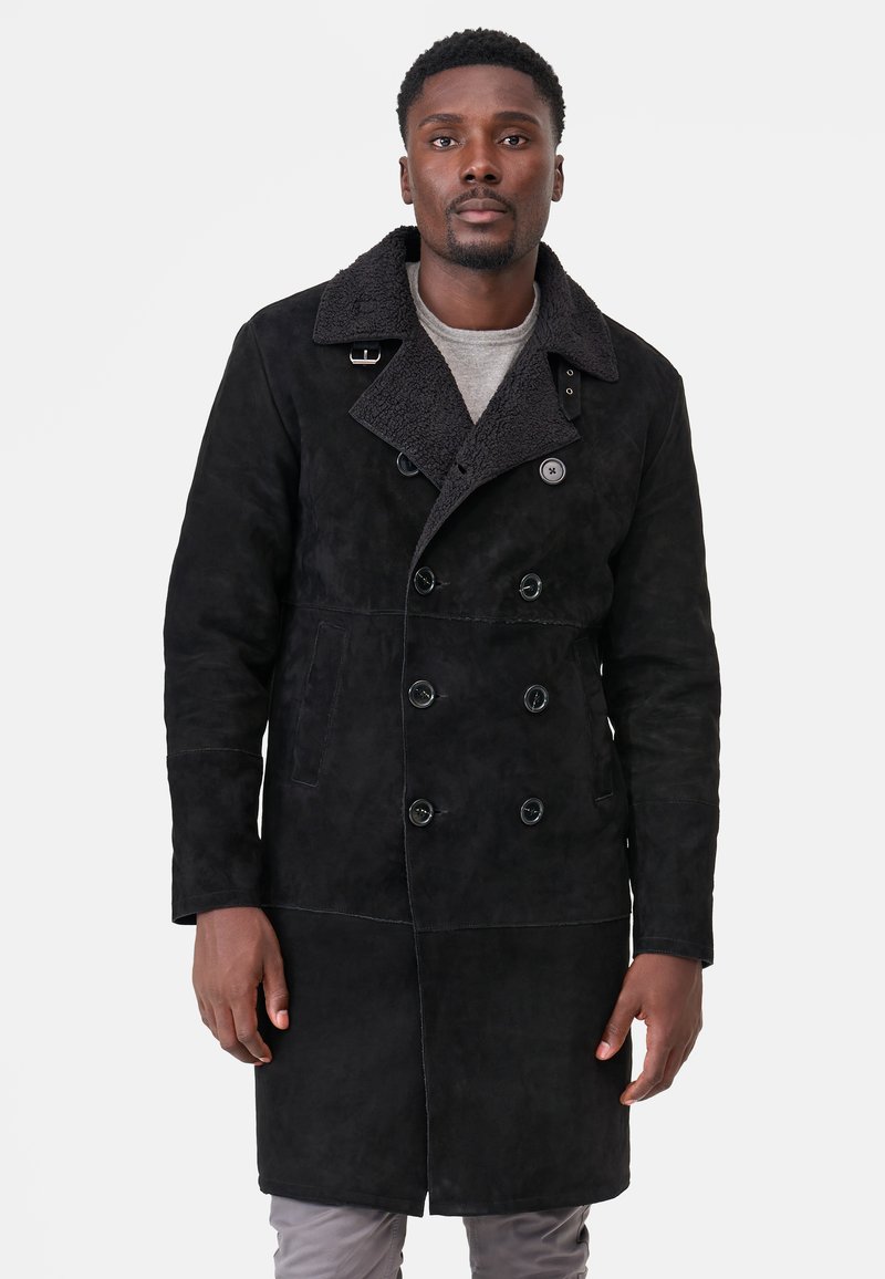 Sort dobbeltrådet frakke i blødt ruskind med en struktureret krave, store knapper og sidelommer, med en mellemlang design.