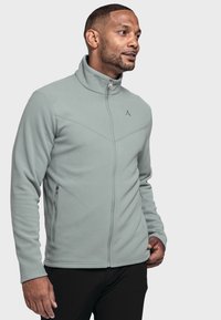 Helle grüne Fleecejacke mit hohem Kragen, Reißverschlussfront und zwei Seitentaschen. Verfügt über ein diagonales Nähmuster und Logo-Details.