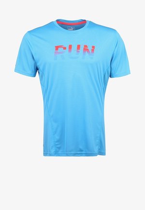 Jasnoniebieska koszulka sportowa z napisem "RUN" w czerwonym i niebieskim gradiencie, w połączeniu z czarnymi legginsami i białymi trampkami z niebieskimi akcentami.