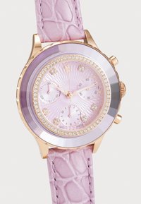Orologio in oro rosa con cinturino in pelle lilla caratterizzato da un motivo coccodrillo. Il quadrante presenta un design a raggio di sole con tre sottocassi e dettagli in cristallo.