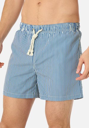 Männlicher Torso mit blau-weiß vertikal gestreiften Badeshorts, die an der Taille mit einem weißen Kordelzug gebunden sind.