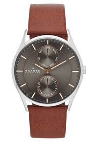 Orologio al quarzo con quadrante rotondo grigio scuro, tre sotto-quadranti per il giorno e la data, cassa argentata e cinturino in pelle marrone.