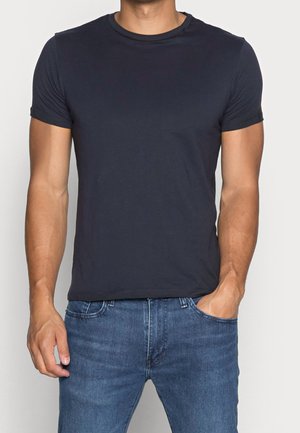 Marineblaue Rundhals-T-Shirt, kurze Ärmel, figurbetontes Design, aus weichem Stoff, kombiniert mit hellblauen Jeans. Einfach, einfarbig.