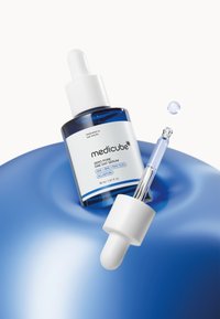 Serum Medicube Zero Pore w niebieskiej szklanej butelce z białym zakraplaczem. Etykieta zawiera biały tekst na niebieskim tle, podkreślający składniki.