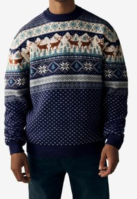 Maglione lavorato a maglia blu navy con motivi invernali, tra cui renne, fiocchi di neve e alberi nei colori blu, crema e marrone.