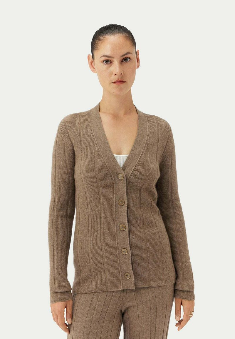 Brun ribbad stickad cardigan med djup V-ringning, sex knappars stängning och långa ärmar. Texturerat tyg och figurnära design.