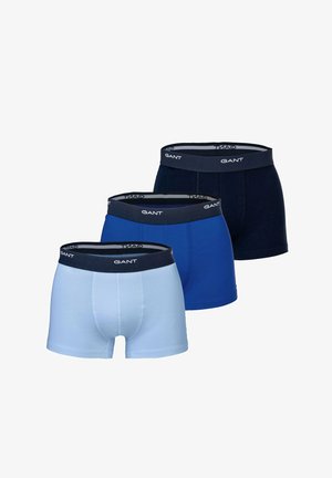 Drei Paar Herren-Boxershorts in Hellblau, Königsblau und Marineblau, jeweils mit einem dunklen Bund mit dem Markenschriftzug "GANT".