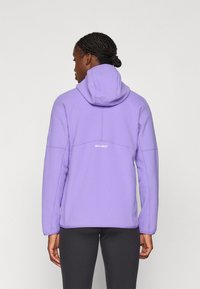 Purple fleece hoodie with a hood, featuring a smooth texture, simple design, and logo accent on the back. Worn with black leggings.