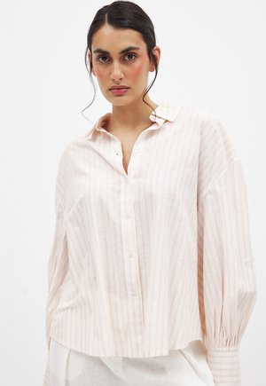 Blusa a rayas rosa claro con botonera en la parte delantera, mangas oversize, textura suave y ajuste relajado. Ideal para ropa casual.