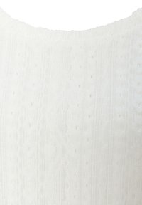 Nahaufnahme eines weißen, strukturierten Kleidungsstücks mit einem gerippten Kragen und einem feinen Muster aus kleinen Perforationen, die in den Stoff eingewebt sind.