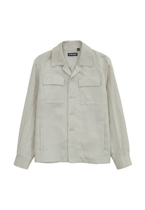 Giacca camicia beige chiaro a maniche lunghe con colletto aperto, chiusura frontale con bottoni e due tasche sul petto con patta.