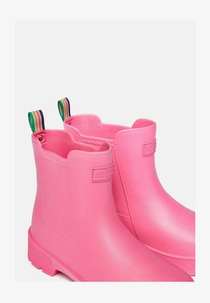 Růžové gumové kotníkové boty s hladkou texturou, kontrastními zelenými a proužkovanými úchyty a raženým logem na boku.