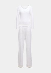 Biely súprava na voľný čas pozostávajúca z dlhého rukáva s ozdobným výstrihom a zodpovedajúcich nohavíc s čipkovou lemovkou na okraji. Mäkká textúra.