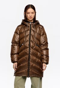 Brązowa puchowa kurtka z pikowanym wzorem w jodełkę, kapturem, dwoma zapinanymi na zamek bocznymi kieszeniami oraz zamkiem błyskawicznym na całej długości. Faktura błyszcząca, o wyraźnym wykończeniu.