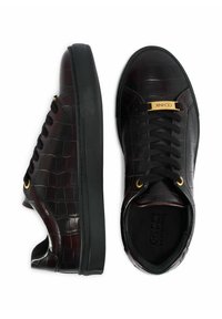 Czarne sneakersy z teksturowanej skóry o wzorze krokodyla, z złotymi akcentami, czarnymi sznurowadłami i gumową podeszwą zapewniającą przyczepność. Widok z góry.