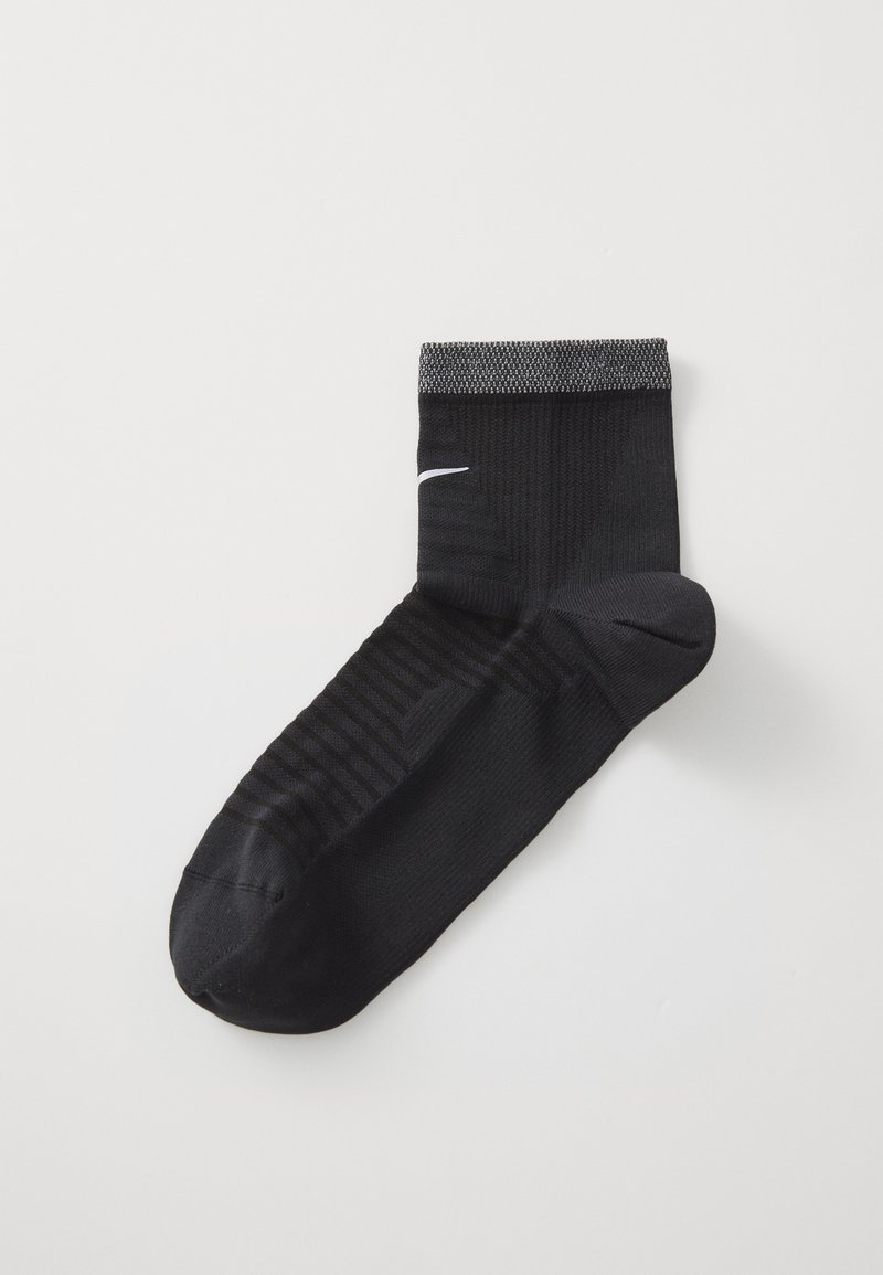 Chaussette de sport noire avec une partie supérieure texturée, un bout renforcé et un logo blanc sur le côté. Dispose d'un poignet côtelé pour un ajustement sécurisé.