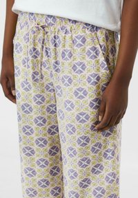 Lekka, wzorzysta bielizna nocna z kwiatowym wzorem w odcieniach fioletu, żółci i różu, z elastycznym pasem i bocznymi kieszeniami.