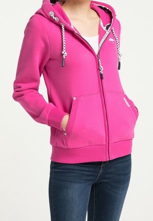 Haut à capuche zippé rose vif avec un cordon de serrage, comportant deux poches avant et des poignets côtelés. Texture lisse, design décontracté.