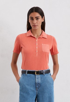 Short-sleeve, collared polo shirt in coral with a front button placket and a chest pocket; cotton material, soft texture, casual fit.